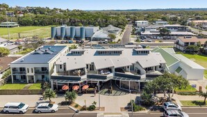 Un hotel moderno con diversi edifici, un parcheggio e vista sulla zona circostante.