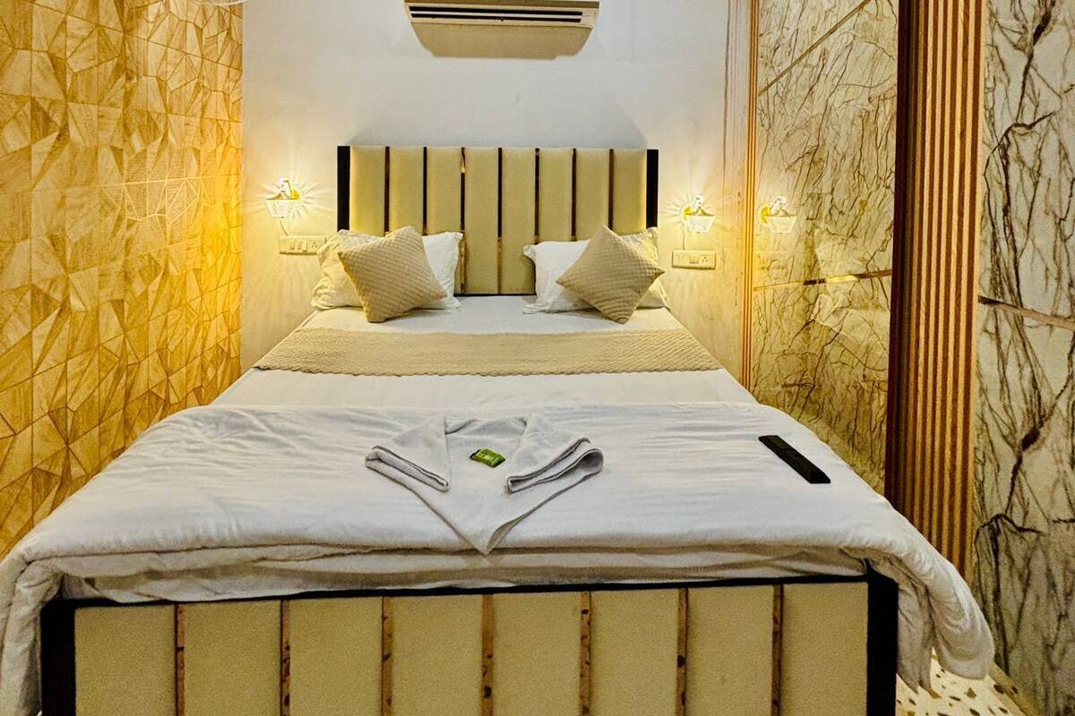 A modern bedroom with a wooden ceiling, a marble-patterned wall, a bed with a headboard, and an air conditioning unit.