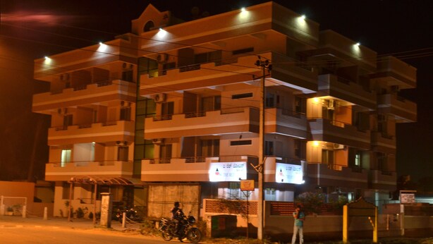 A multi-story building with balconies and a ground-level entrance. - THE RED LOTUS GRAND (Mysore)
