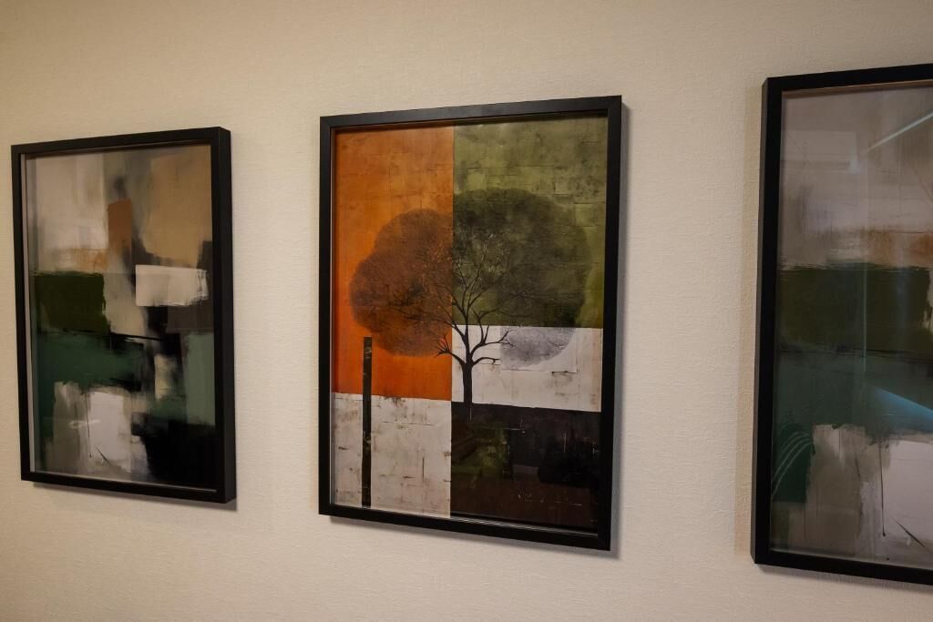 Three framed artworks on a wall.