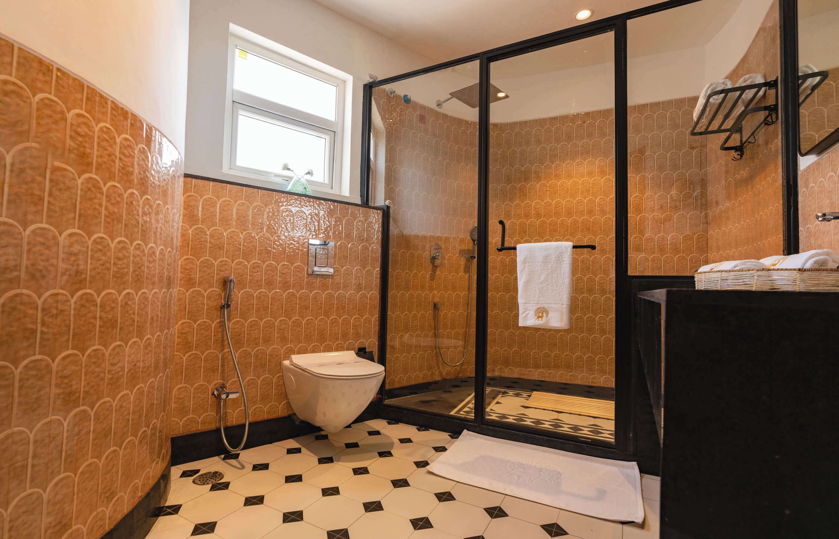 A bathroom with a glass-enclosed shower, a toilet, and a sink.