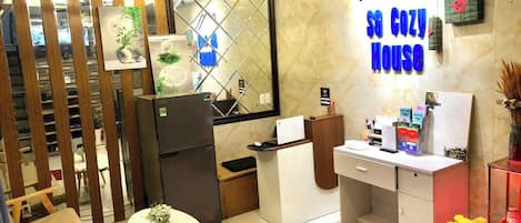 Una cocina compacta con refrigerador, pileta y un pequeño comedor con mesa y sillas.