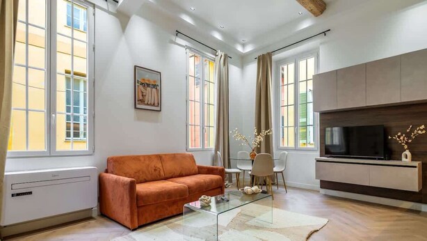 Een moderne woonkamer met een bank, een glazen salontafel, een televisie en een open haard.