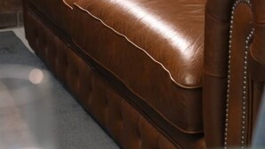 A brown leather sofa with a tufted backrest and decorative stitching. - Modern 3-Bedroom Stay | Walk to Shops & Dining (Robertson)