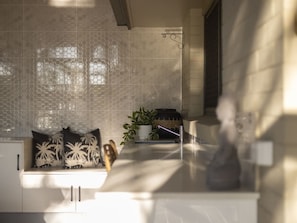 Een moderne badkamer met een glazen douchewand, een wit wastafelmeubel en een plant.
