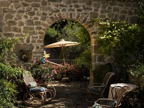 An outdoor seating area with wicker chairs and a table, an archway, and a potted plant. - Country House / Farm House in Forcella with 2 bedrooms sleeps 5 (Forcella)