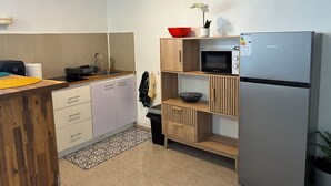 A modern kitchen with a sink, stove, microwave, and refrigerator.