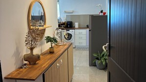 A modern kitchen with a wooden countertop, a built-in washing machine, and a refrigerator.