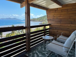 A wooden balcony with a view of the ocean and mountains. - T2 cosy Côte îlots au bord de la plage vue panoramique, coucher de soleil. (Canton d'Acoua)