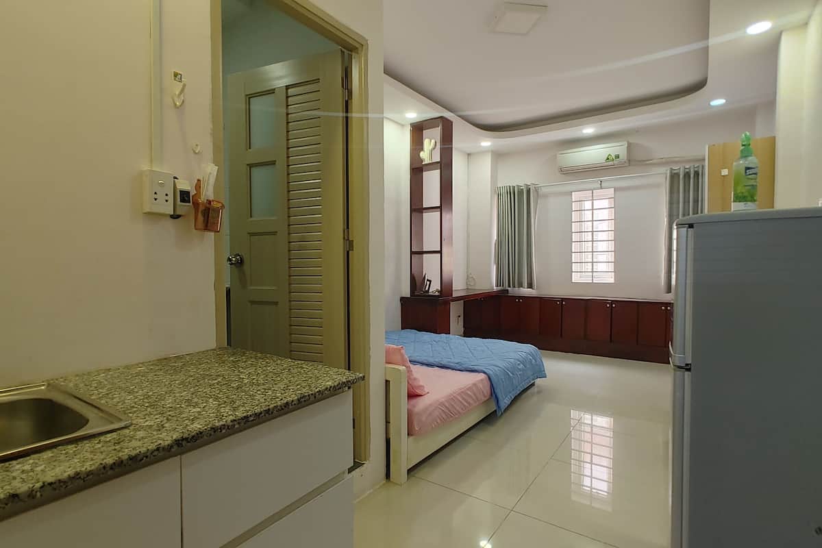 A compact kitchen with a granite countertop, a sink, and a refrigerator.