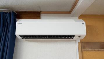 A white Daikin air conditioner mounted on a wall with a wooden trim and a white curtain.