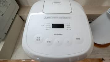 Een wit, draagbaar apparaat met Japanse knoppen en een scherm, waarschijnlijk een draagbare koffiemachine of een vergelijkbaar apparaat.