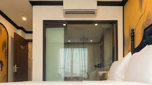 A hotel room with a bed, a large window with curtains, an air conditioning unit, and a door with a number. - D'Lux Hotel (Hanoi)