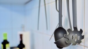 Kitchen utensils hanging on a rack.