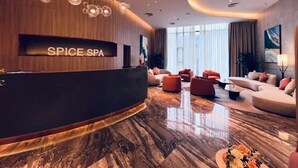 A modern spa lobby with a reception desk, plush seating, and a large window providing natural light. - Sea view Àlacarte Ha Long Bay Apartment (Bai Chay)