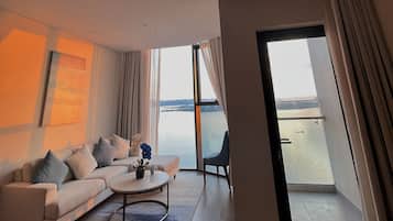 Departamento Deluxe, balcón, vista a la playa | Área de sala de estar