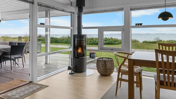 A modern interior with a wood-burning stove, large windows, and a view of the sea. - "Gertje" - 20m from the sea by Interhome (Assens)