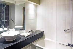 A modern bathroom with a round sink, a bathtub, and a glass shower enclosure. - Atlantic Tower hotel by Sunday Junior Suite (Liverpool)