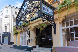 A building with a sign reading 'THE GRAND' and a wrought iron structure above the entrance. - Bristol Grand Hotel By Sunday - Junior Suite (Bristol)
