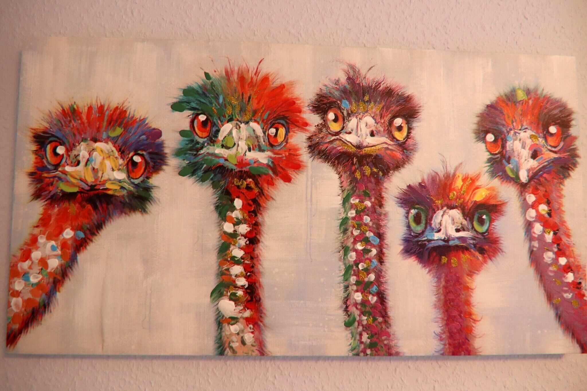 Un tableau représentant cinq oiseaux aux couleurs vives, avec des yeux et des plumes bien marqués.