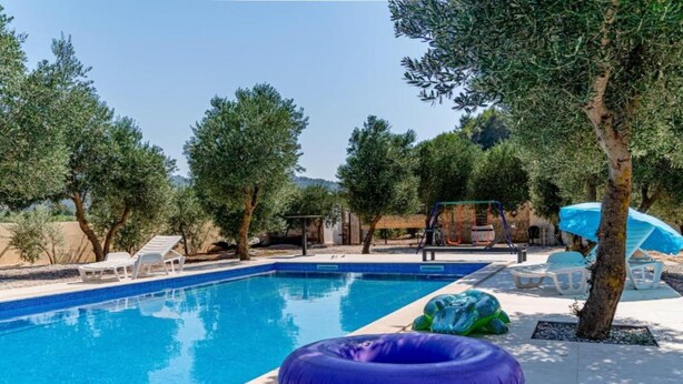 A swimming pool with lounge chairs and a water slide. - Natur Olive House Ston (Ston)