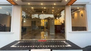A hotel entrance with a glass door, a checkered floor mat, and a ceiling with recessed lighting. - Hotel Town Star (Srinagar)