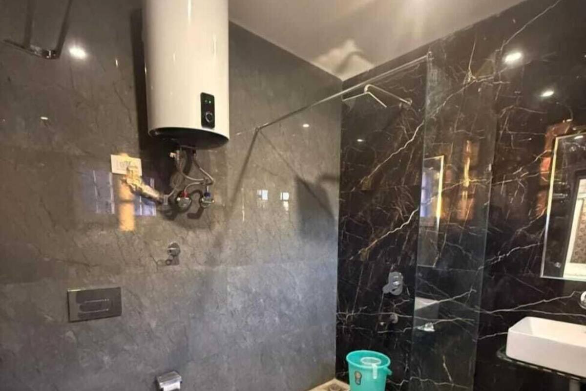 Uma casa de banho moderna com sanita, cabine de duche e lavatório.