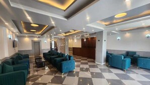A lobby with checkered flooring, teal sofas, and recessed lighting. - Hotel Town Star (Srinagar)