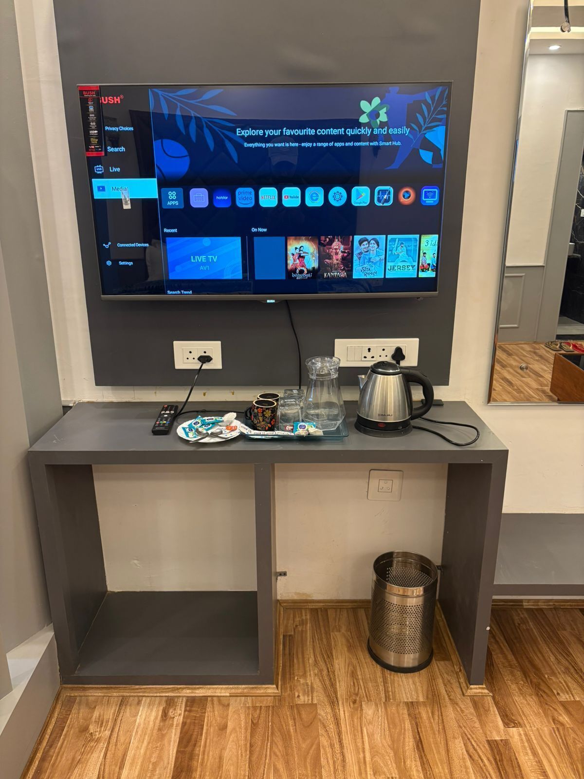 A flat-screen TV mounted on a wall with a digital interface displaying various content options.