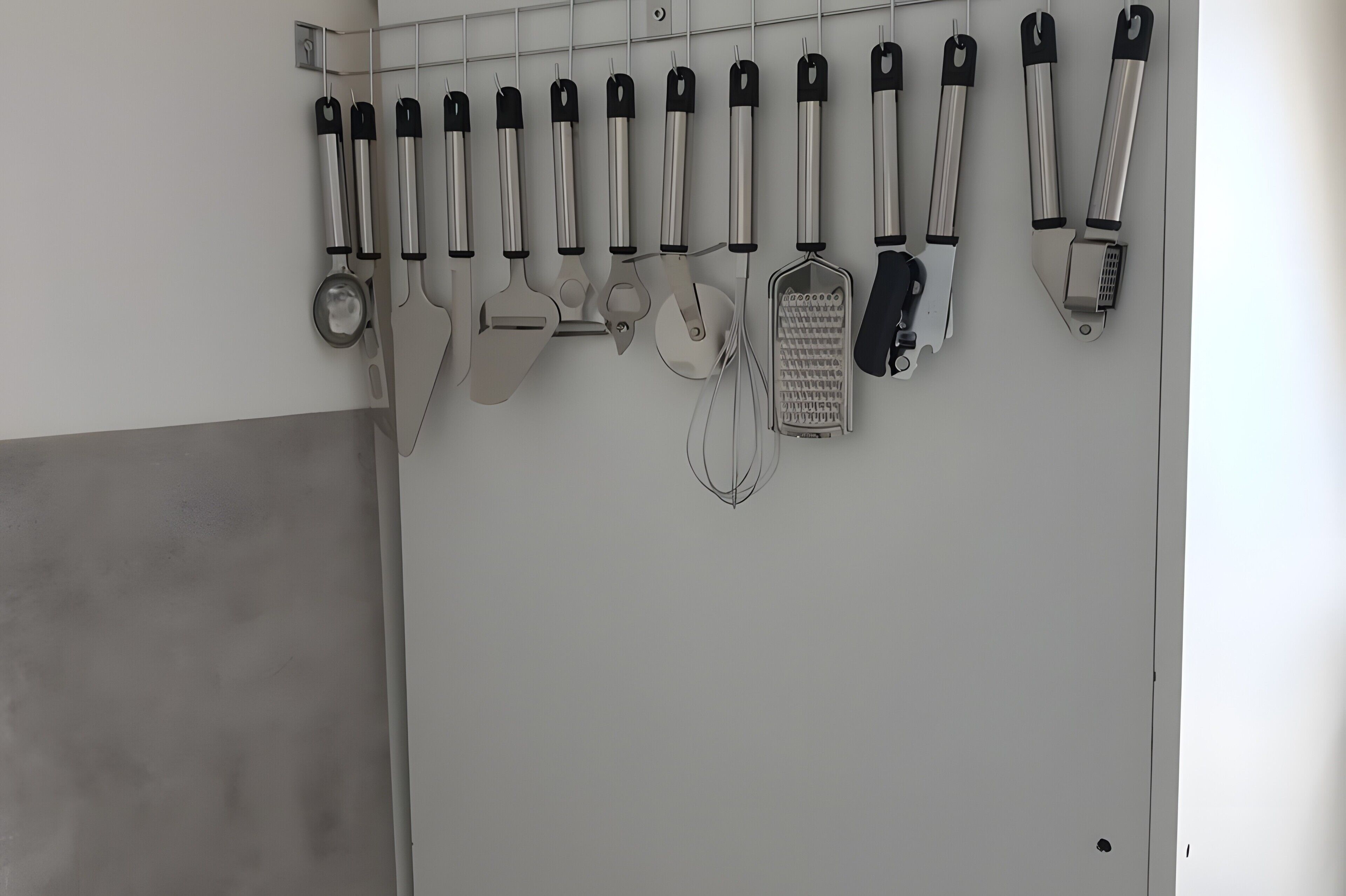 Un porte-ustensiles fixé au mur, contenant divers accessoires de cuisine.
