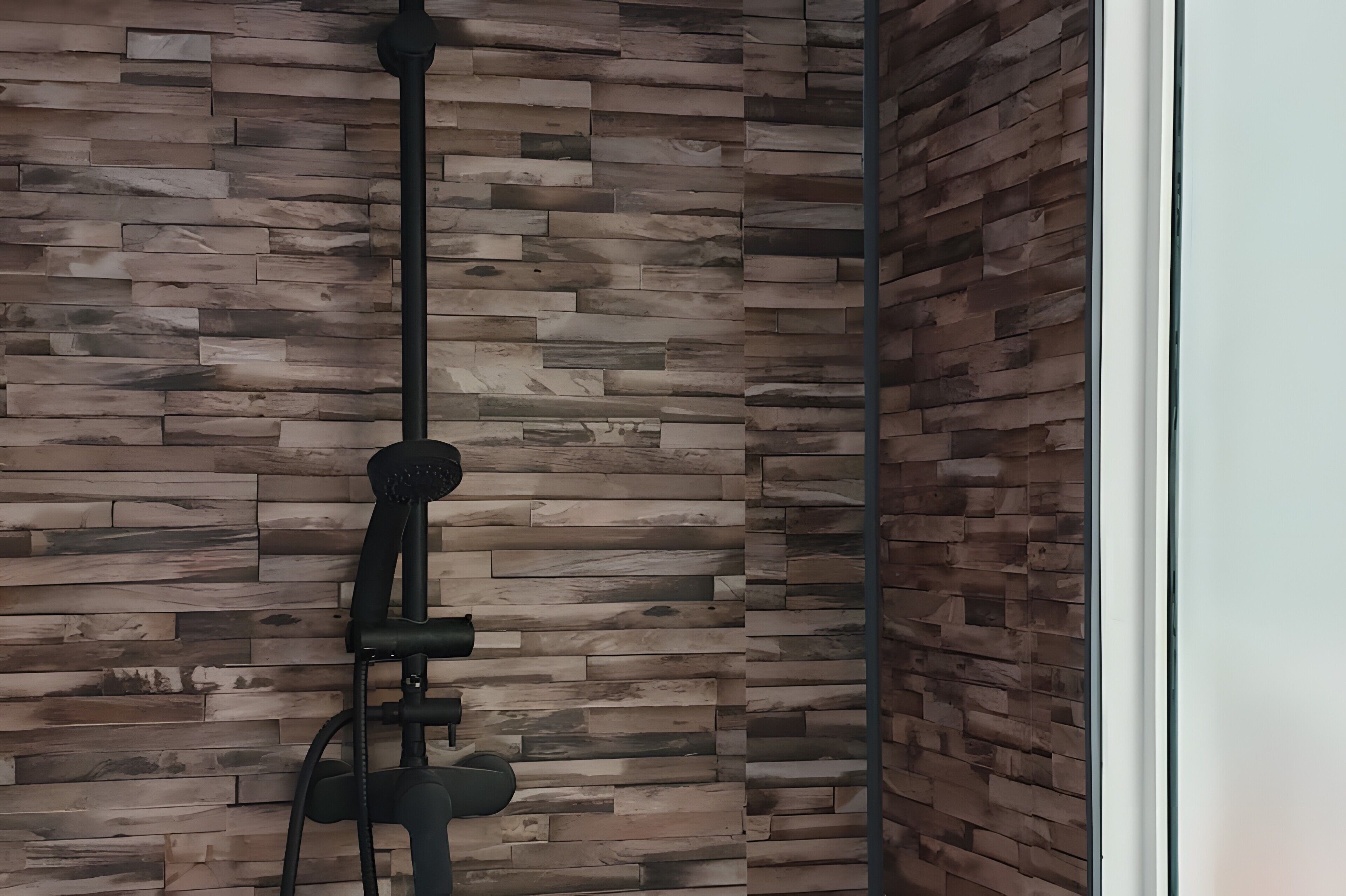 A room with a wooden wall and a black object, possibly a piece of furniture or equipment.