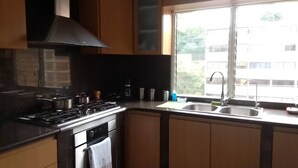 Uma cozinha com fogão, forno e pia.