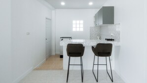 Una cocina moderna con dos taburetes de bar, una ventana y una encimera.