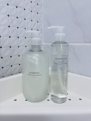Dos botellas de líquido sobre un estante blanco.