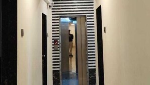 Un pasillo con piso de baldosas, una lámpara en el techo y una puerta con el número del piso indicado.