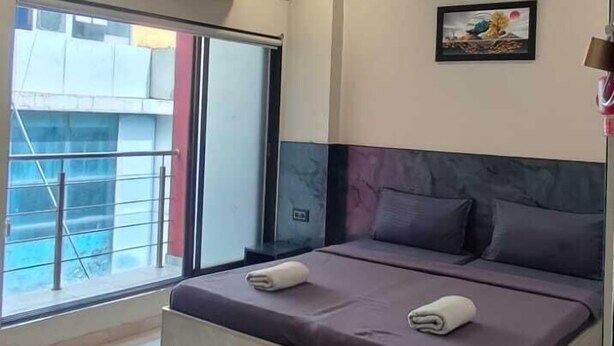 Un dormitorio moderno con una cama grande, ventilador de techo y aire acondicionado.