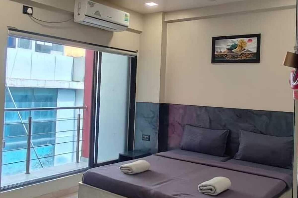 Ein modernes Schlafzimmer mit einem großen Bett, Deckenventilator und Klimaanlage.