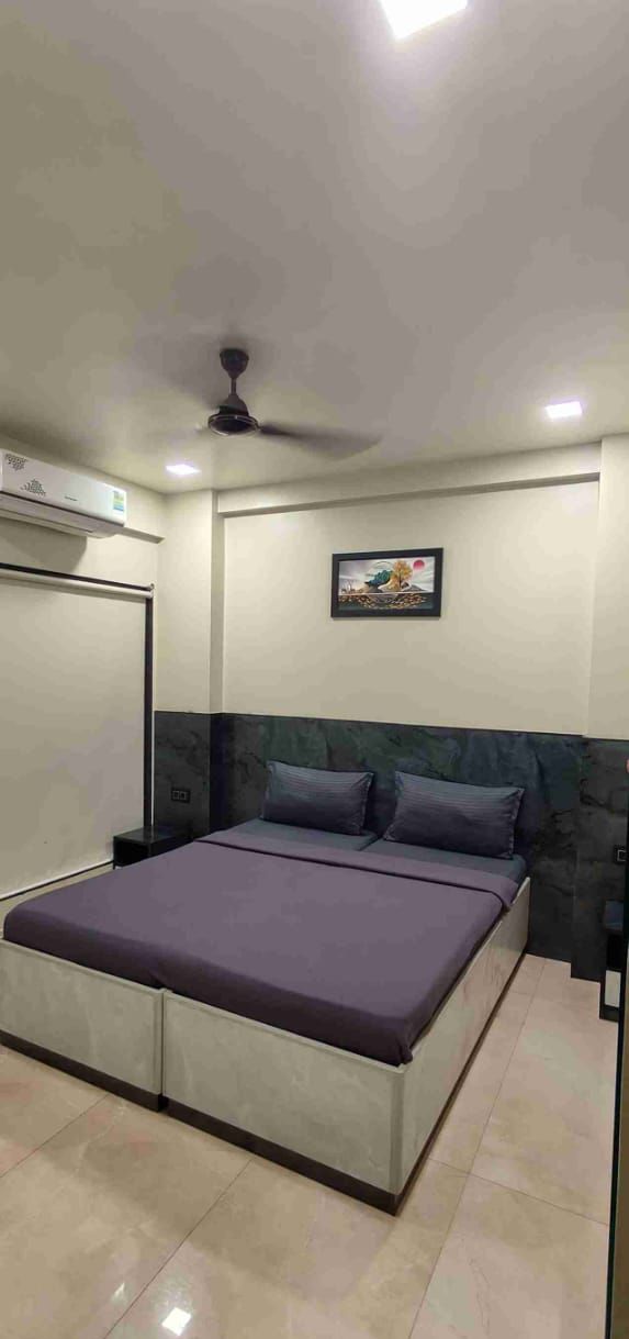Un dormitorio moderno con cama, ventilador de techo y aire acondicionado instalado en la pared.