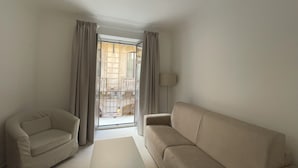 Un salon moderne avec un canapé, un fauteuil et une table basse.