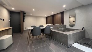 A modern kitchen with a dining area, a built-in sink, and a large mirror. - Suwon Hound Hotel (Suwon)
