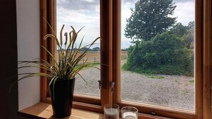 A window with a potted plant, two candles, and a view of a rural landscape. - 1 bedroom beautiful apartment in Vallåkra (Vallåkra)