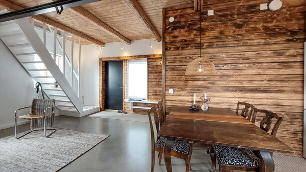 A dining area with a wooden table and chairs, a bench, and a staircase leading to an upper level. - 1 bedroom beautiful apartment in Vallåkra (Vallåkra)
