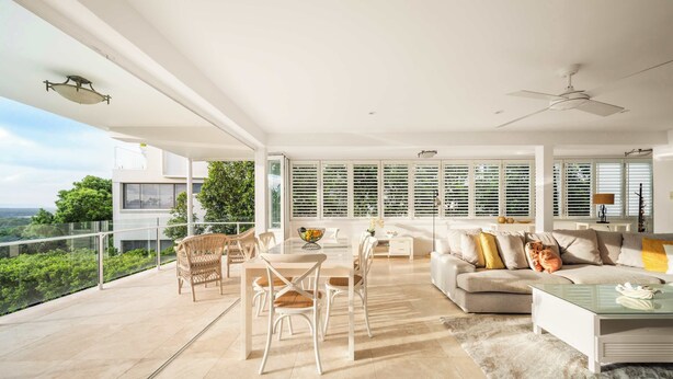 A spacious living area with a balcony, a dining set, and a sofa. - Picture Perfect - Panoramic Views, Walk to Beach (Noosa Heads)