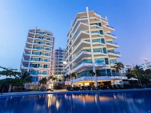 A modern hotel with multiple floors, balconies, and a pool area. - Luxurious 3-bedroom Apartment With Shared Pool in Bolívar (Cartagena)