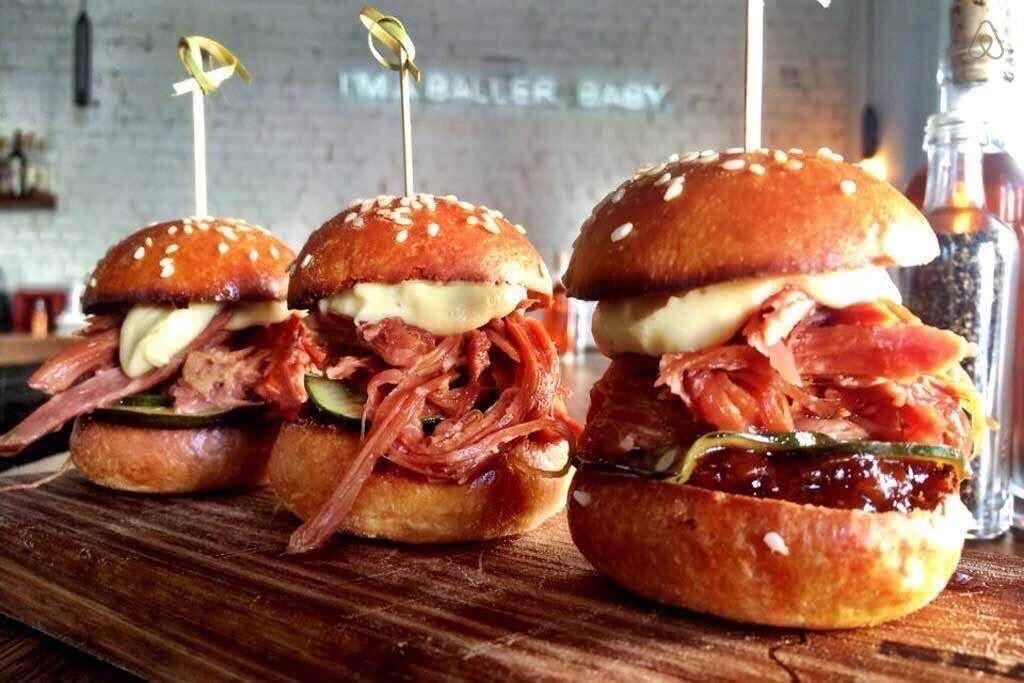Three sandwiches with toothpicks, placed on a wooden surface.