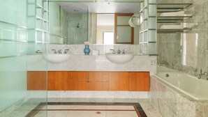 A modern bathroom with two sinks, a large mirror, and a glass-enclosed shower area. - Stylish & Cozy 4BR Retreat With Free Parking (Melbourne)