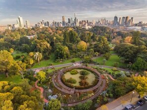 Un parque con un jardín circular y un horizonte urbano al fondo.