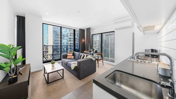A modern apartment with a kitchen, dining area, and living room.