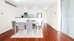 Une cuisine moderne avec des meubles blancs, un four à micro-ondes et un réfrigérateur.