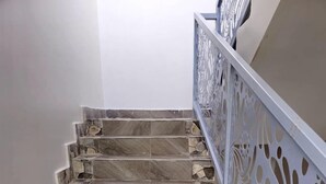 Een trap met stenen treden en een witte balustrade met decoratieve uitsparingen.